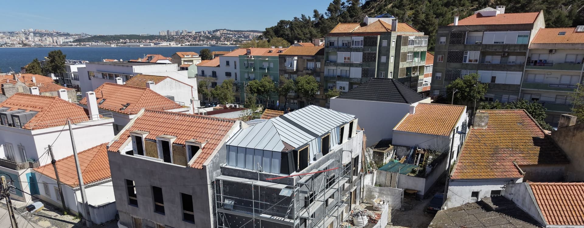 Building under construction in Trafaria, with the Tagus and Lisbon behind